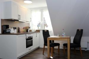 a kitchen with a table and two chairs and a table and a stove at Lieblingshaus Fiete in Prerow