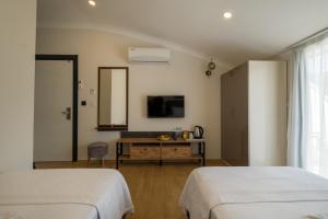 a bedroom with two beds and a desk and a mirror at Tanrise City House in Fethiye