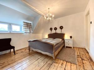 a bedroom with a bed and a chandelier at Dom Ogrodnika in Biała Olecka