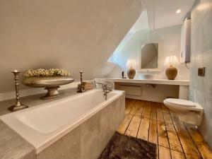 a bathroom with a tub and a toilet and a sink at Dom Ogrodnika in Biała Olecka +17 photos