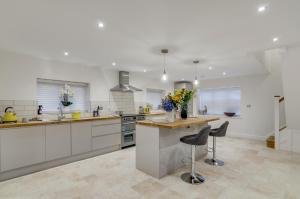 a kitchen with white cabinets and a counter with flowers on it at Luxury 6 bed with parking near broads in Clippesby