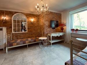 a bedroom with a bed and a brick wall at Dom Ogrodnika in Biała Olecka