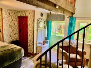 リースにあるThe Little Barnの階段とベッド、窓が備わる客室です。