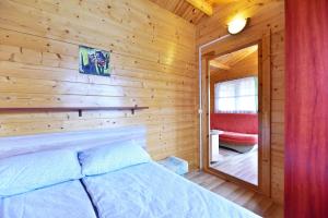 a log cabin bedroom with a bed and a mirror at Nameliai Gulbės takas in Šventoji