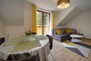 un salon avec une table et un canapé dans l'établissement Apartament Sun & Ski Weekend Willa Nad Łomnicą 15 - centrum 100m, à Karpacz