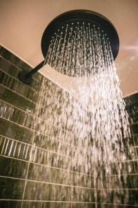 Una ducha con agua saliendo de ella en de Wever Lodge, en Otterlo