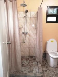een badkamer met een douche en een toilet bij Shambala Paradise in Siquijor
