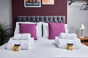a bedroom with purple pillows and a white bed at Delven House, Apartment 4 in Castle Donington