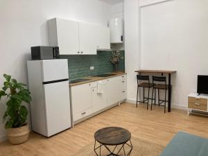 a kitchen with a white refrigerator and a table at Castle View Apartments in Alicante