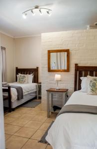 a bedroom with two beds and a mirror at The Vine in Klawer