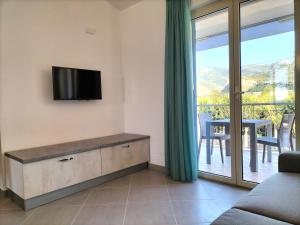 a living room with a flat screen tv on a wall at Icaro Residence Apartments with a beautiful pool in SantʼAgata di Militello