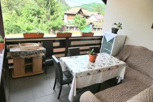 a balcony with a table and a table and a window at Casa Luminita in Brezoi