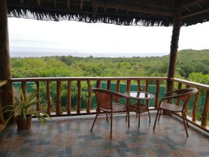 einen Tisch und Stühle auf einem Balkon mit Aussicht in der Unterkunft Shambala Paradise in Siquijor