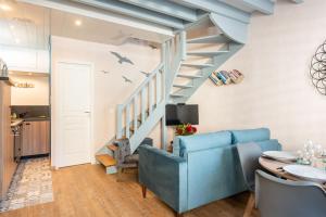 a living room with a blue couch and stairs at Cajem in Étretat