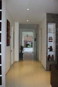 a hallway with white walls and a tile floor at Hostal Villa Manuelita in Pisco