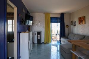 a living room with a couch and a kitchen at Salento Sea & Sun Apartment in Porto Cesareo