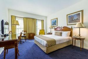 a hotel room with a bed and a desk at Quality Hotel Canterbury International in Forest Hill