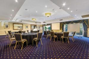 a conference room with tables and chairs and a projection screen at Quality Hotel Canterbury International in Forest Hill