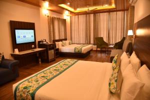 a hotel room with a bed and a television at Mastiff Wildcrest Outer Dharamshala Near Chamunda Devi Temple in Pālampur +52 photos