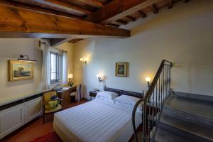 sypialnia z białym łóżkiem i schodami w obiekcie Hotel Mulino di Firenze - WorldHotels Crafted we Florencji
