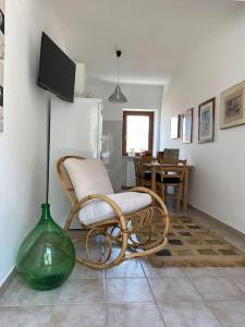 La Casa dei Nonni في Avigliano: غرفة معيشة مع كرسي و مزهرية