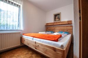 a wooden bed in a room with a window at Green Garden Apartments Soklič in Bohinj