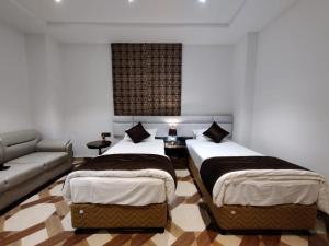 a living room with two beds and a couch at Royal Bliss in Patna