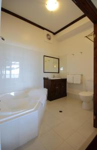 a bathroom with a tub and a toilet and a sink at Anchorage Seafront Hotel in Victor Harbor