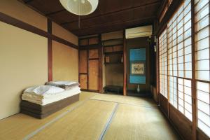 a room with a bed in a room with windows at Gojo Guesthouse - Annex in Kyoto