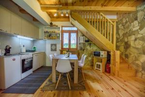 a kitchen with a table with chairs and a staircase at Sterling Lodge in Kolašin