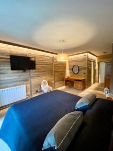 1 dormitorio con 1 cama grande con manta azul en HOTEL LE FONTI, en Lurisia