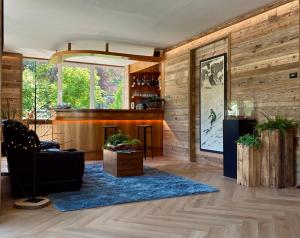un soggiorno con pareti in legno e un tappeto blu di HOTEL LE FONTI a Lurisia