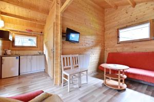 a living room with a red couch and a table at Nameliai Gulbės takas in Šventoji
