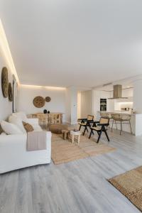 ein Wohnzimmer mit einem weißen Sofa und einem Tisch in der Unterkunft Casa Boma Lisboa - Unique Apartment with Swimming Pool - Marvila I in Lissabon
