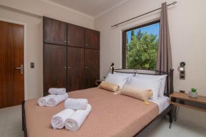 a bedroom with a bed with towels on it at Arokaria apartment in Alikanas