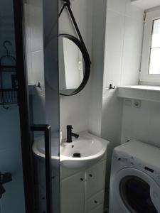 łazienka z umywalką i pralką w obiekcie Apartamenty u Darka w Ustce