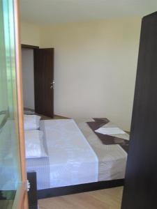 Rayski zalez في بوموري: غرفة نوم بها سريرين مع ملاءات بيضاء