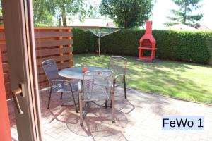 a patio with a table and chairs and a playground at Zum Kranichblick FeWo 1&2 in Niepars