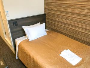 een hotelkamer met een bed met twee handdoeken erop bij HOTEL LiVEMAX Sendai Kokubuncho in Sendai