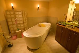 a bathroom with a large tub and a sink at Mercator-Hotel in Gangelt