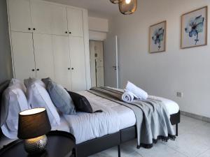 ein Schlafzimmer mit einem großen Bett mit weißen Wänden in der Unterkunft Kay's City & Seaview One Bedroom Apartment in Larnaka