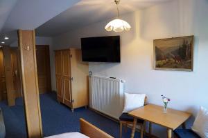 a hotel room with a table and a tv on the wall at Haus Alpenland in Mariazell