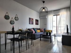 ein Wohnzimmer mit einem Sofa und einem Tisch in der Unterkunft Kay's City & Seaview One Bedroom Apartment in Larnaka
