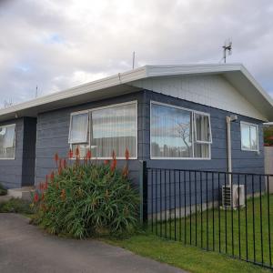 una casa azul con una valla delante de ella en Family friendly unit, en Hastings