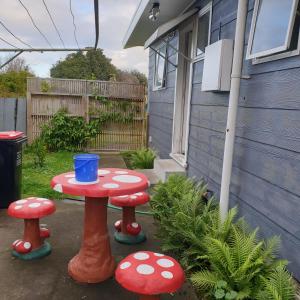a table and two mushroom stools in a yard at Family friendly unit in Hastings