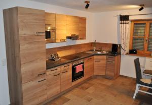 een keuken met houten kasten en een wastafel bij Ferienwohnung Reiter in Anger