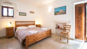 1 dormitorio con 1 cama grande y 1 silla en Casa Colombo & Casa Scipione by Rentbeat, en Ostuni