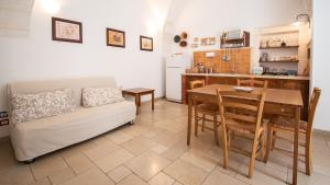 cocina y sala de estar con mesa y sofá en Casa Colombo & Casa Scipione by Rentbeat, en Ostuni