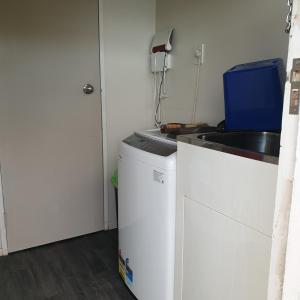 a kitchen with a sink and a washing machine at Family friendly unit in Hastings