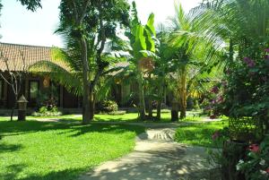 ペムテランにあるVan Karning Bungalowの椰子の木が茂る庭園を通る小道